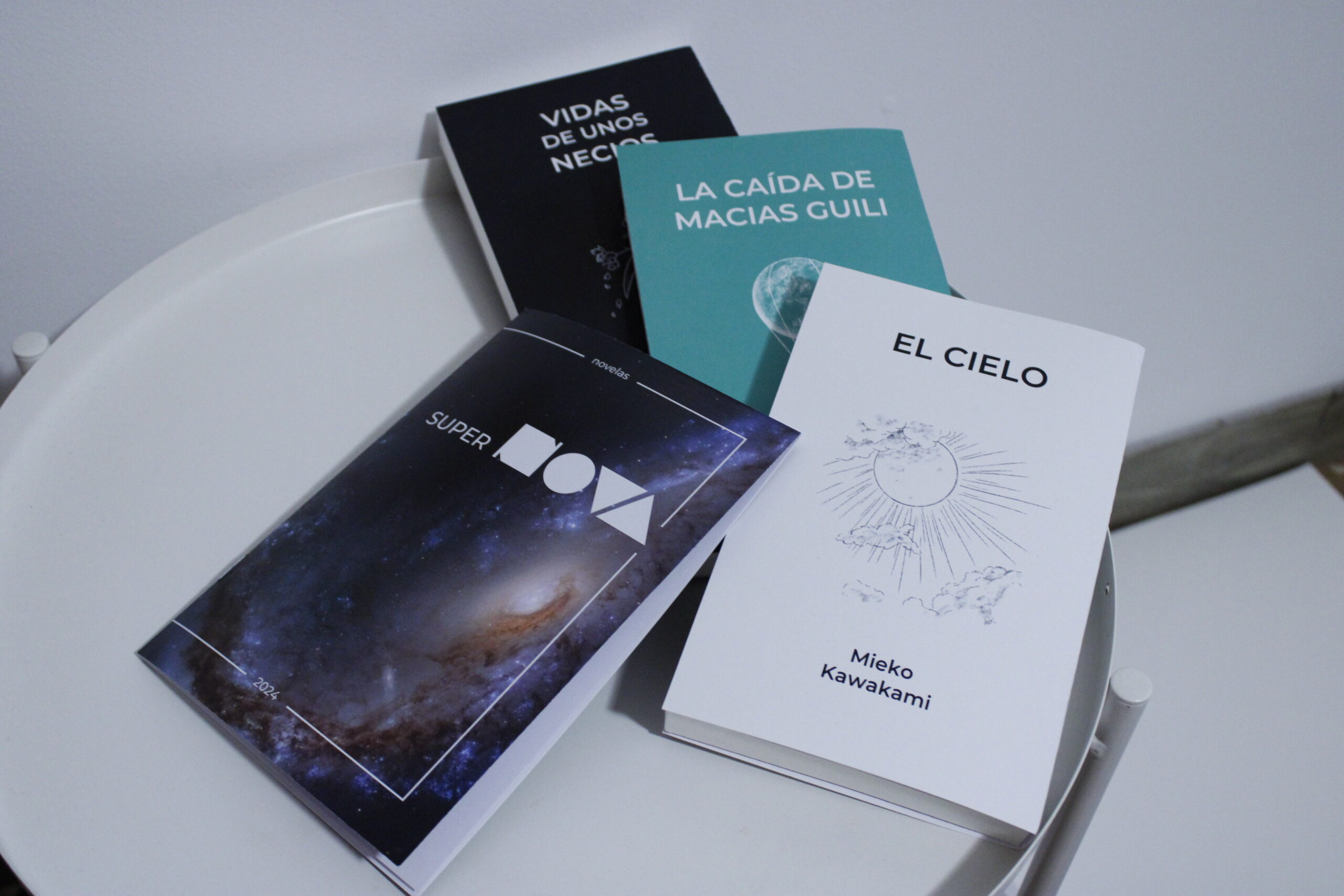 Tres libros y el folleto corporativo de la editorial SuperNOVA dispuestos sobre una mesa