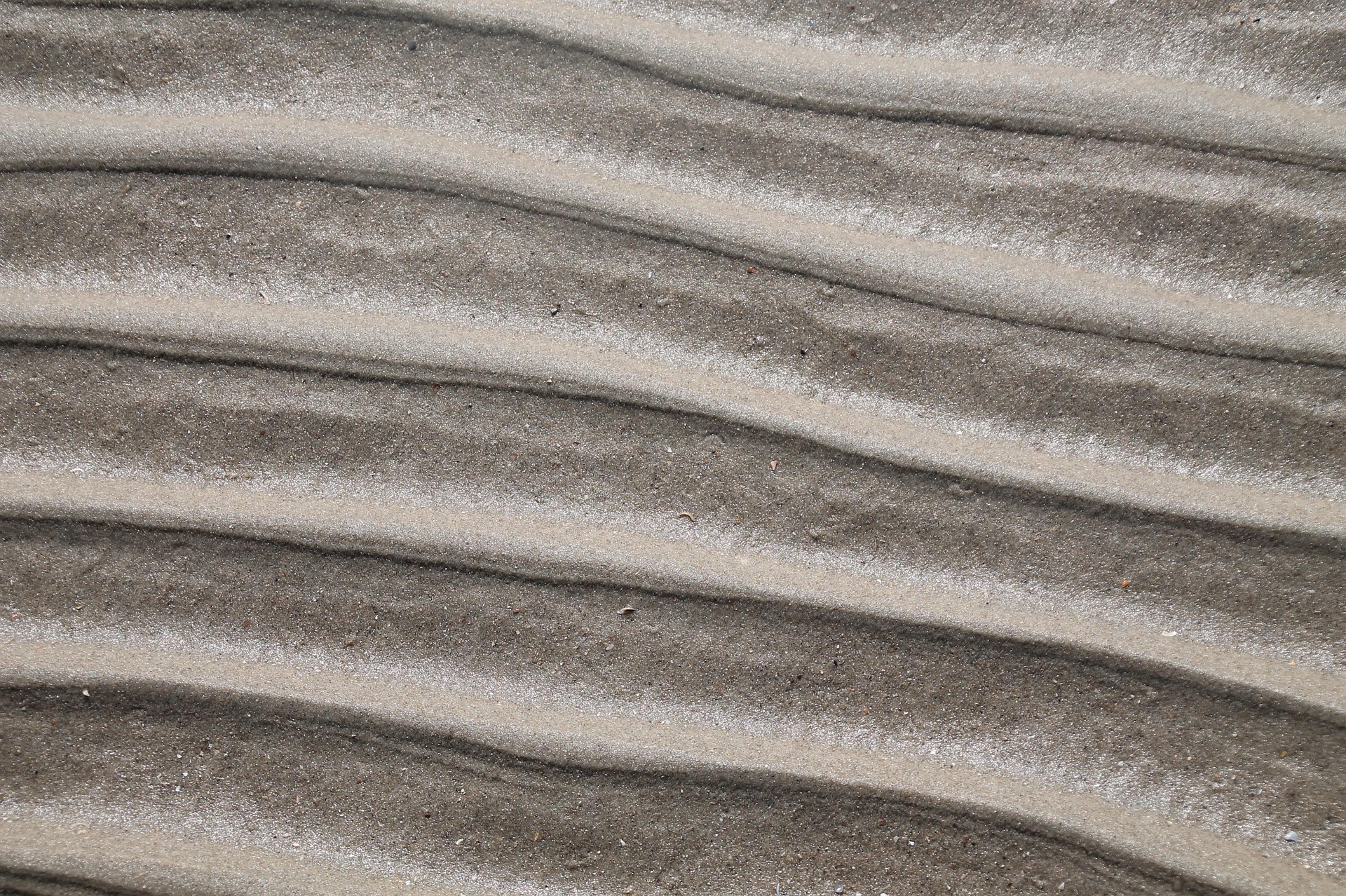 Fotografía del padrón de las olas sobre la arena.