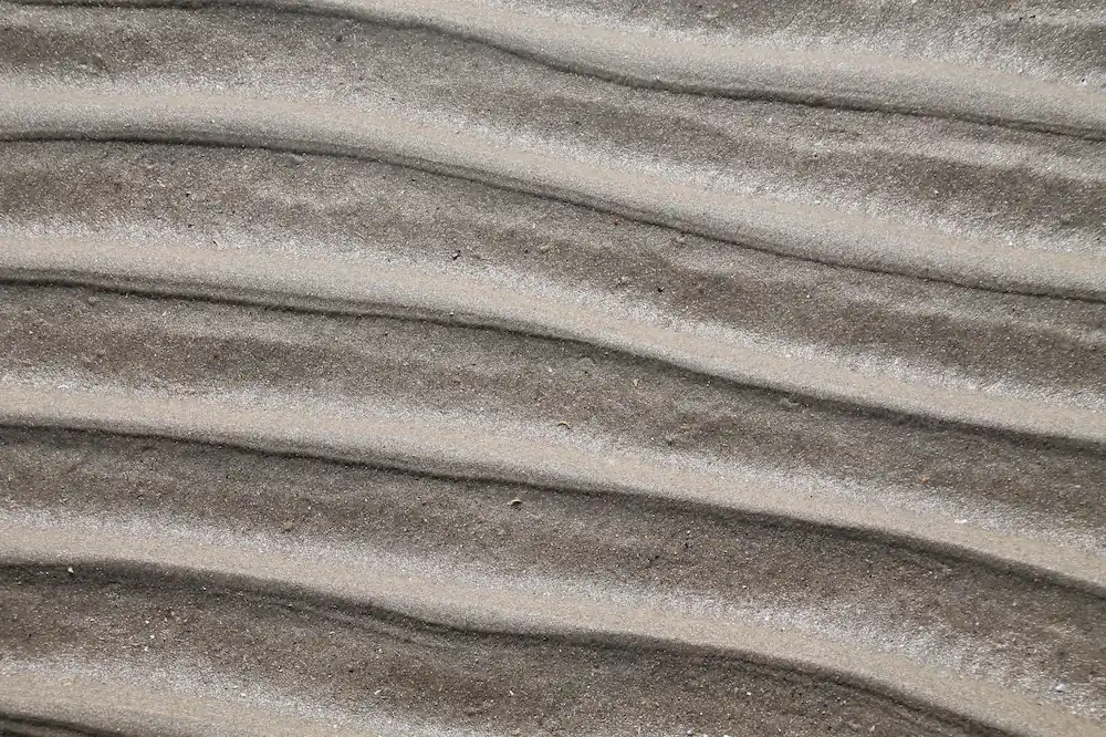 Fotografía del padrón de las olas sobre la arena.